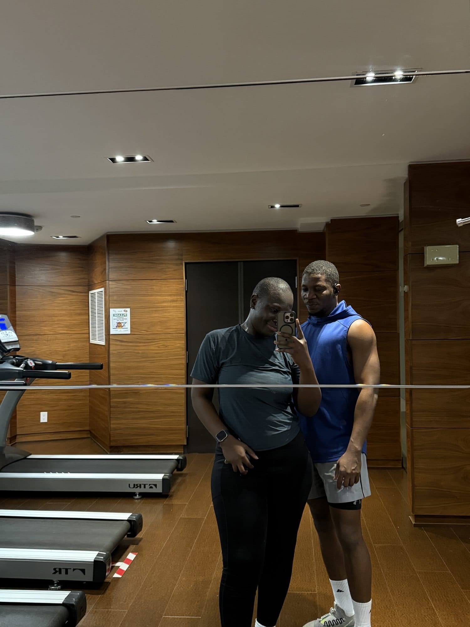 Femi and his wife in a gym mirror selfie