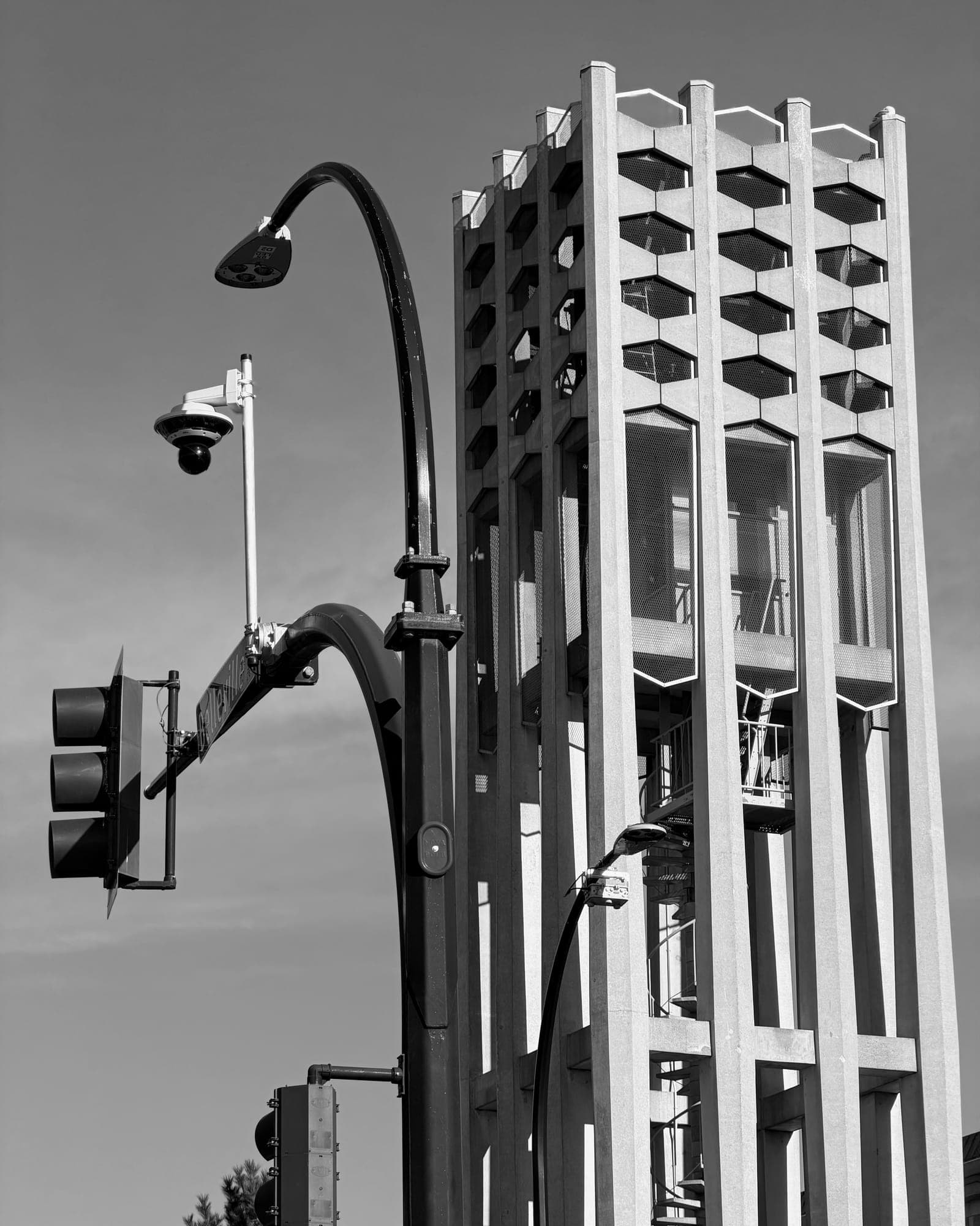 The Netherlands Centennial Carillon tower beside a traffic signal and lamp post, in black and white