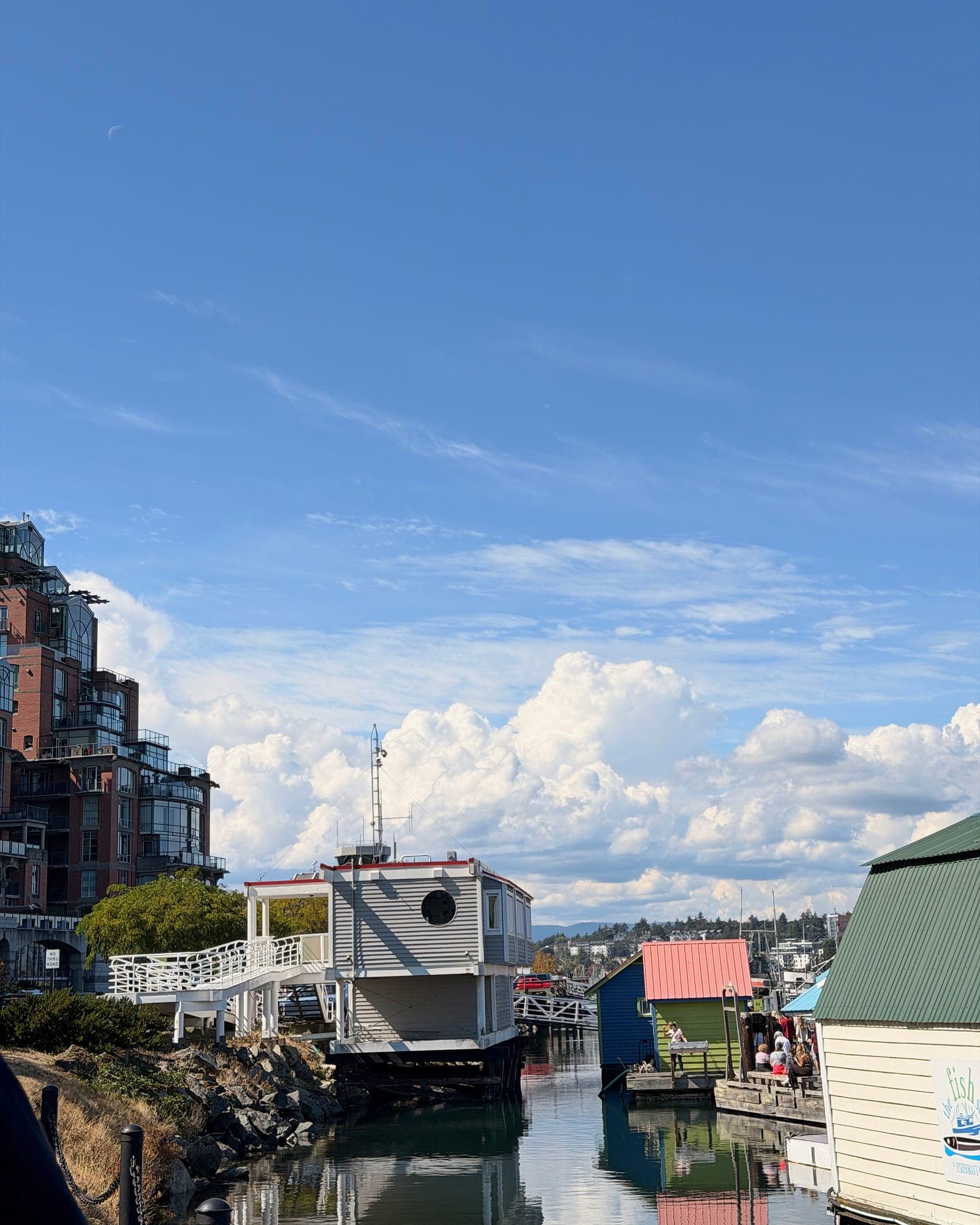 Float homes and a condo tower under a broken cloud sky