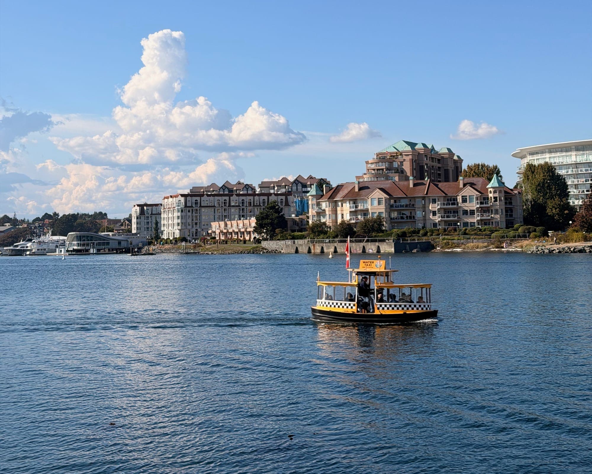 A yellow harbour ferry crossing the Inner Harbour toward the waterfront