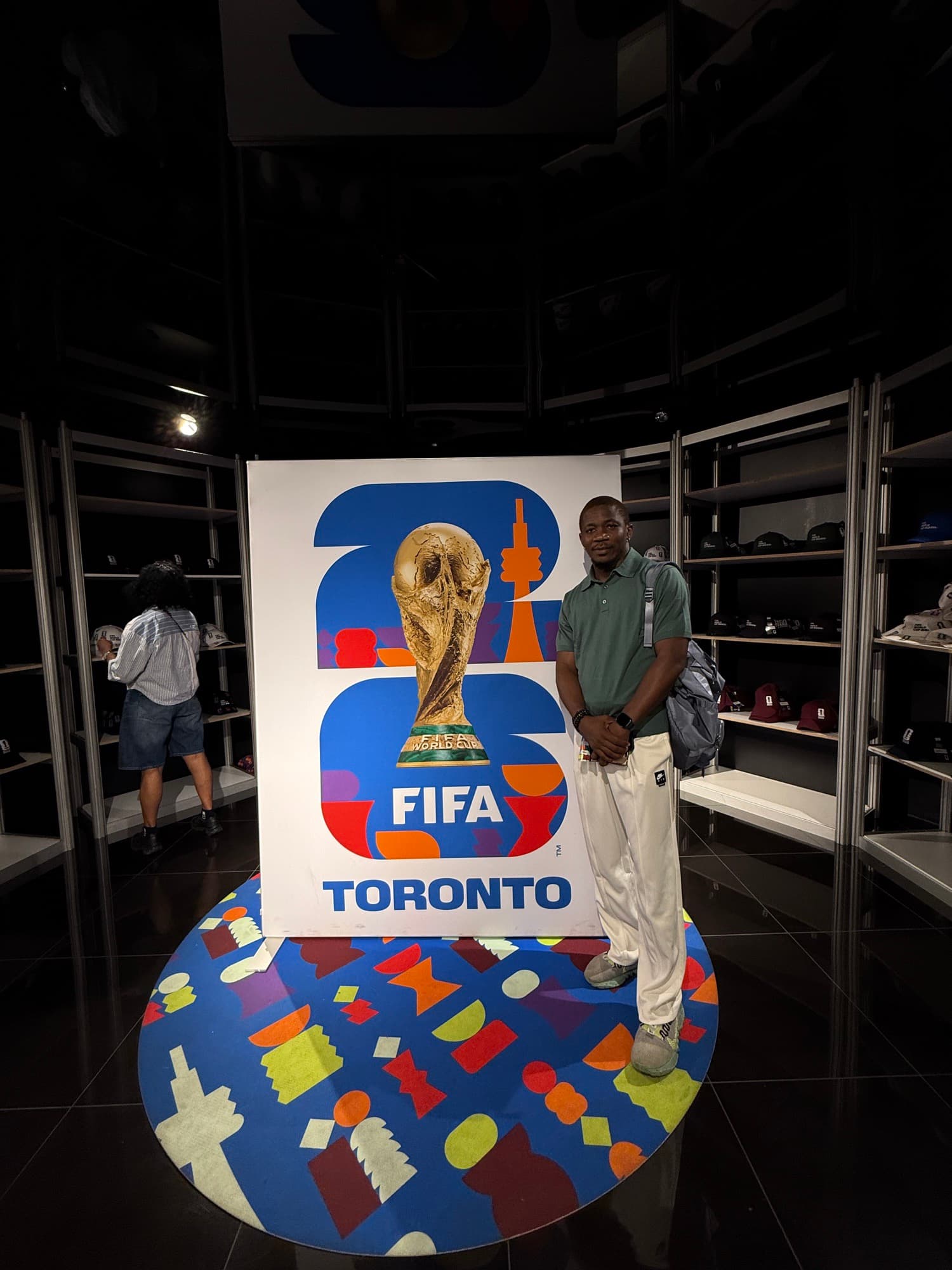 Posing with the FIFA World Cup trophy display at the FIFA 26 Toronto exhibit